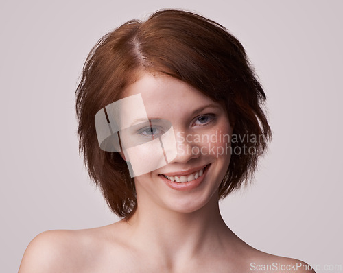 Image of Portrait, woman and skincare with smile in studio, white background and red hair with treatment for self care. Face, and glow with natural routine for smooth, skin and confidence with moisturizer