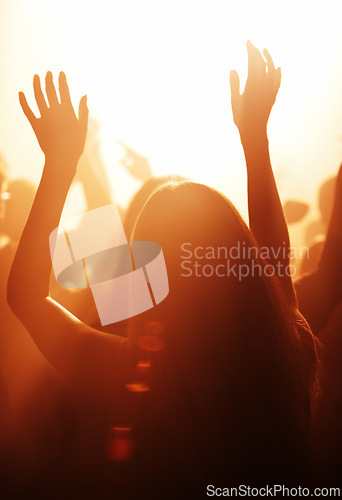 Image of Woman, live and festival with arms raised to listen, music and dance with crowd, cheering and dancing to performance on stage. Audience, enjoy and singing with loud, sound and partying with band.