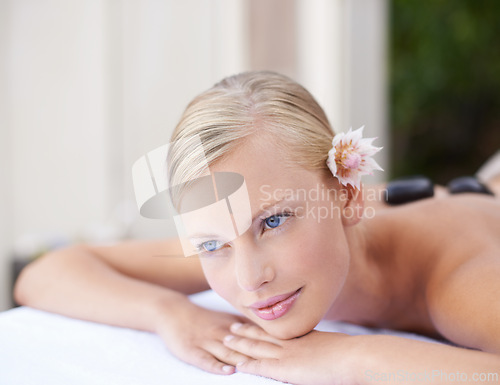 Image of Spa, woman and thinking on massage bed with relax for wellness, zen or beauty treatment for body care. Person, thoughtful and satisfaction at resort, salon table and luxury on holiday or vacation