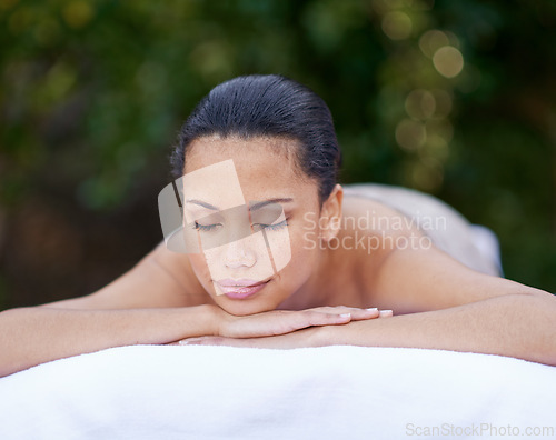 Image of Spa, woman and relax on massage bed with smile for wellness, zen and beauty treatment for body care. Person, sleeping and stress relief at resort, salon table and peaceful on holiday or vacation