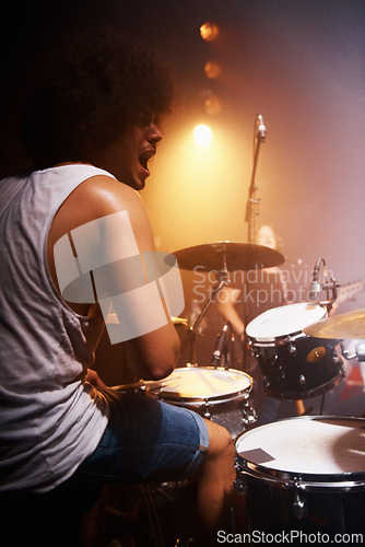 Image of Stage, performance and drummer at concert with man in band with energy and talent for music. Drums, musician and person playing in theater spotlight with rhythm for instrument and show at night