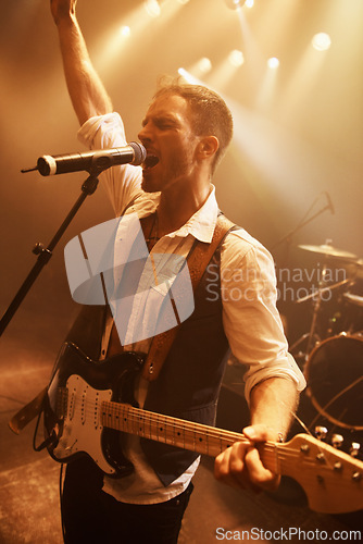 Image of Night, singer and guitar with man on stage for music, performance and rock show. Event, spotlight and concert with male musician playing instrument at festival club for rave, disco and celebration