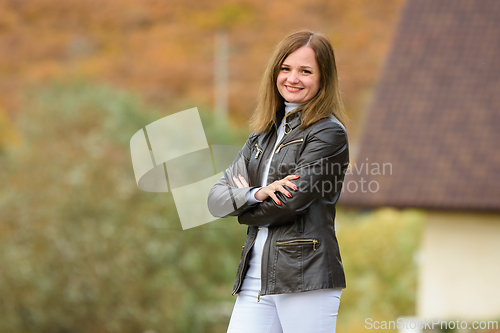Image of Portrait of a young beautiful girl in casual clothes against the background of a blurred autumn forest