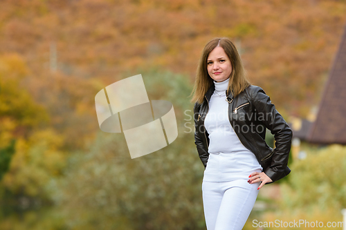 Image of Young beautiful girl in casual clothes against the background of a blurred autumn forest