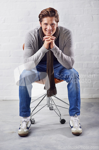Image of Fashion, portrait and happy man thinking on a chair with memory, insight or solution on wall background. Face, idea and male person with problem solving solution, answer or plan, inspiration or guess