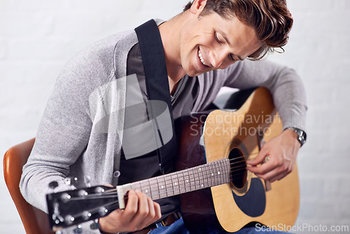 Image of Music, smile and happy man with guitar for artistic, sounds or creative expression on wall background. Musical, instrument and male person with acoustic, melody or feel good hobby, fun or practice