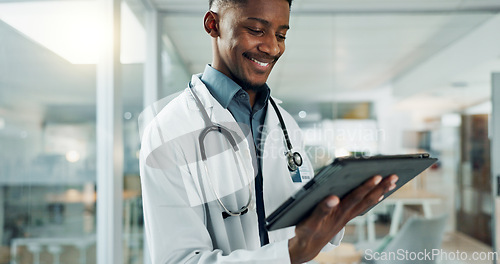 Image of Tablet, research and happy black man doctor on internet for medical or healthcare information online in a hospital. Smile, medicine and professional typing on health website or app in a modern clinic