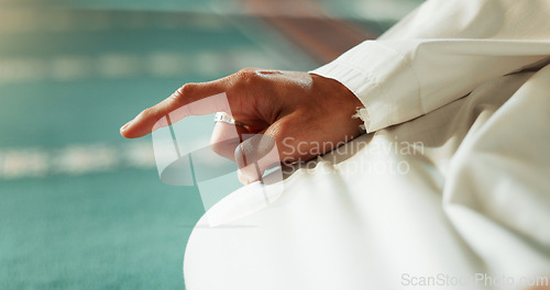 Image of Islam, floor and closeup of a pointing finger or person at a mosque for praying, hajj or support. Muslim, hope and hand of a man for a prayer, gesture or worship for respect, religion or trust