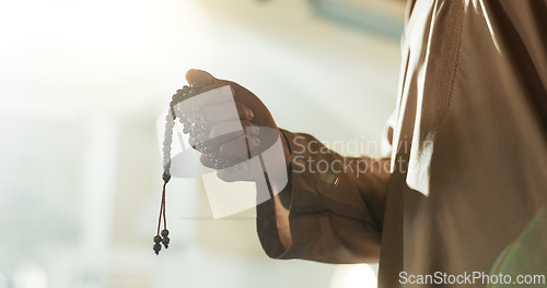 Image of Prayer, beads and hand of muslim man in mosque, temple or Islam worship of Allah in spiritual, meditation or respect. Islamic, faith and praying in the morning for mindfulness, hope and love of God