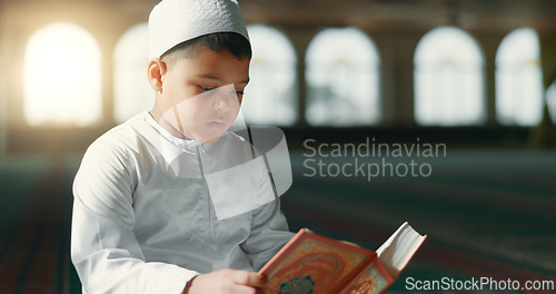 Image of Islam, child in mosque reading Quran for learning, mindfulness and gratitude in faith with prayer. Worship, religion and Muslim student in holy temple praise with book, spiritual teaching and study.