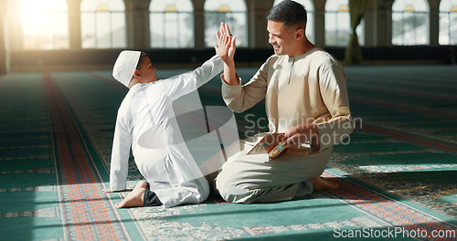 Image of Muslim, high five in a mosque and a father with his son to study the quran for faith, belief or religion together. Family, kids and ramadan with a man teaching his boy child about islamic success