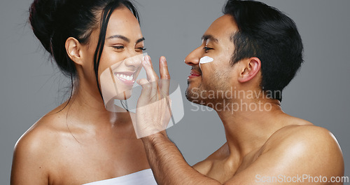 Image of Couple, smile and love for skincare, care and portrait with moisturizer in studio by gray background. Happy people, dermatology and hug for cosmetics, hydration and creme or love for skin treatment