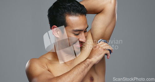 Image of Happy asian man, deodorant and armpit for hygiene, grooming or fresh smell in against a grey studio background. Male person smile for cleaning, cosmetics or self care in skincare or product on mockup