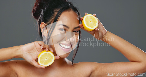 Image of Face, skincare and woman with lemons for beauty in studio isolated on gray background. Portrait, natural fruits and food of happy model for cosmetics, healthy diet and nutrition for organic vitamin c