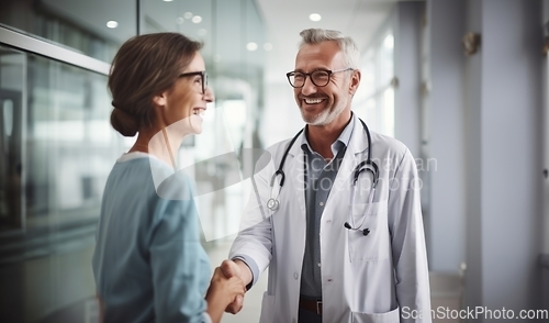 Image of In a modern hospital corridor, doctors exchange handshakes, reflecting professional unity and collaborative teamwork