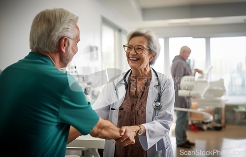 Image of A compassionate female doctor shares a handshake with an elderly man, symbolizing gratitude and successful completion of hospital treatment