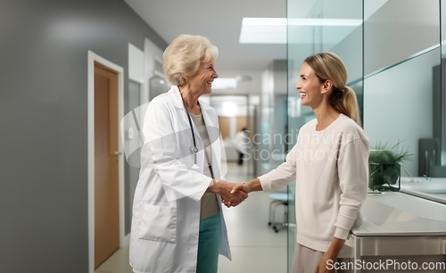 Image of A compassionate doctor shares a handshake with her patient, signifying a successful and trustful completion of hospital treatment