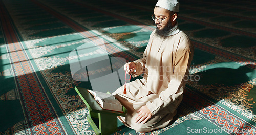 Image of Islam, praying and man in mosque with Quran, mindfulness and gratitude in faith reading. Worship, religion and Muslim Imam in holy temple for praise with book, spiritual teaching and peace meditation