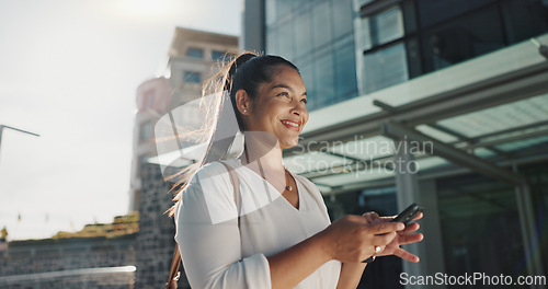 Image of Phone, smile and wind with businesswoman in city, walking on street or sidewalk for morning work commute. Contact, mobile or social media with happy young employee in urban town for travel journey