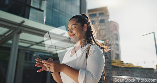 Image of Phone, smile and wind with businesswoman in city, walking on street or sidewalk for morning work commute. Contact, mobile or social media with happy young employee in urban town for travel journey