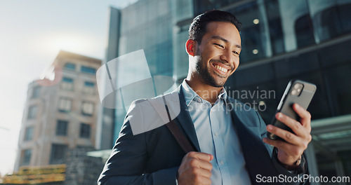 Image of Phone, social media and wind with businessman in city, walking on street or sidewalk for morning work commute. Smile, mobile or contact with happy young employee in urban town for travel journey