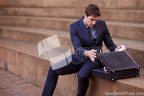 Image of Business, briefcase and man sitting on steps outside law firm in city, outdoor commute and sidewalk of court building. Businessman, lawyer or attorney on outdoor stairs checking bag for travel.