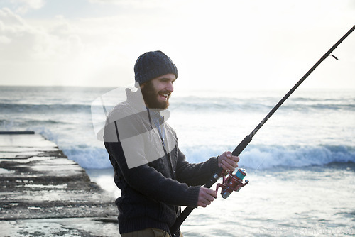 Image of Fishing, smile and travel with man at beach for adventure, holiday and hobby break. Sunset, calm and patience with male fisherman and casting rod pole in nature for recreation, view and vacation