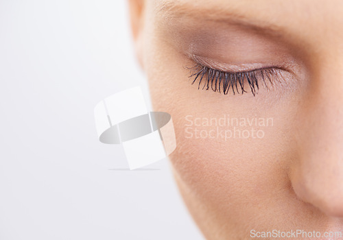 Image of Eye, beauty and makeup with woman closeup in studio on white background for mascara cosmetics. Face, skincare and eyelashes of young model at spa with eyes closed for natural eyebrow dermatology