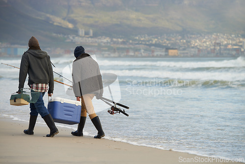 Image of Ocean, fishing and men walking at waves together with cooler, tackle box and holiday conversation. Beach, fisherman and friends with rods, bait and tools on winter morning vacation with mockup space