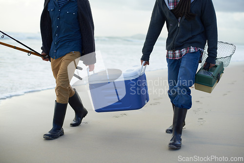 Image of Fishing, walking and men with cooler on beach together with tackle box, water and holiday. Ocean, fisherman and feet of friends with rods, bait and tools at waves on winter morning vacation at sea.