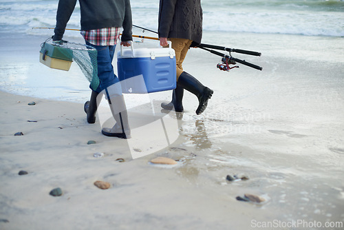 Image of Closeup, walking and beach with fishermen, cooler box and activity with equipment or weekend break. People, ocean or friends with tools for hobby or early overcast morning with waves, sand or seaside