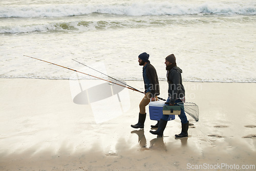 Image of Calm, fishing and men walking on beach together with cooler, tackle box and holiday conversation. Ocean, fisherman and friends with rods, bait and tools at waves on winter morning vacation at sea.