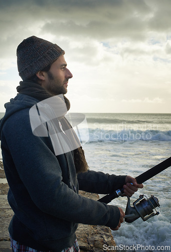 Image of Fishing, relax and travel with man at beach for adventure, holiday and hobby break. Sunset, calm and patience with male fisherman and casting rod pole in nature for recreation, view and vacation