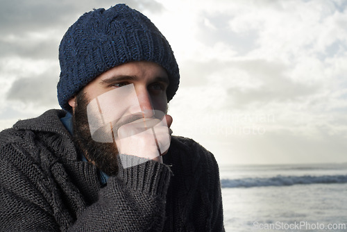 Image of Winter, breathing and ocean with man, thinking and cold weather with waves and freezing. Person, beach or guy with wool jersey or cap with early morning activity or nature with holiday, travel or sky