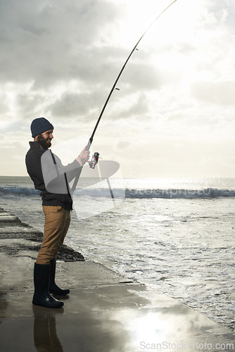 Image of Fishing, holiday and travel with man at beach for adventure, relax and hobby break. Sunset, calm and patience with male fisherman and casting rod pole in nature for recreation, view and vacation