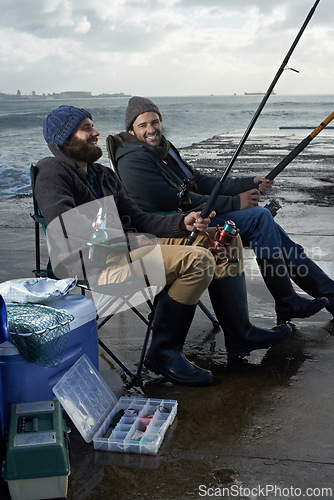 Image of Sea, rod for fishing and men outdoor in winter, leisure activity at beach or harbor with friends in nature for seafood. Travel, ocean and waves with happy fisherman, recreation or hobby in the cold