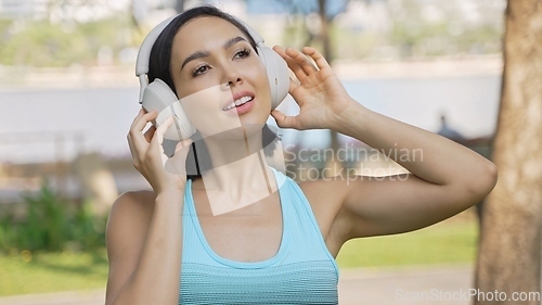 Image of Active Woman Exercising in the Park Listening to Music