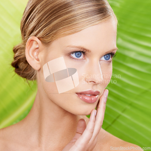 Image of Woman, thinking and skincare with leaf for beauty, detox and organic hydration benefits. Female person, makeup and hand on face with confidence for wellness, glow and daily facial routine in closeup