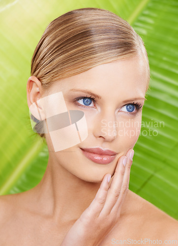 Image of Woman, smile and natural skincare with leaf for beauty, glow and hydration benefits. Female person, makeup and hand on face with confidence for wellness, detox and daily routine on green background