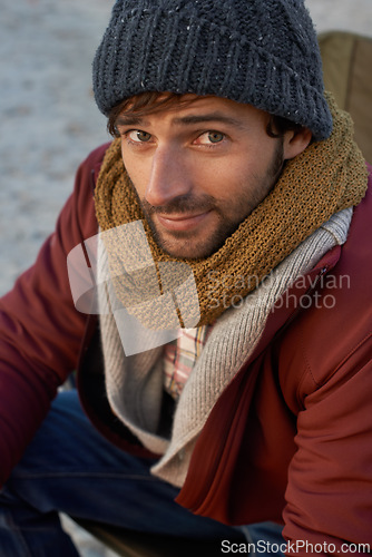 Image of Portrait, fashion and hipster man at beach on winter morning for travel, holiday or vacation. Face, coast or shore with confident young person in beanie and scarf accessories for cold weather season