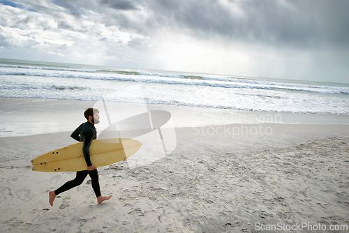 Image of Surfboard, running and man on beach for surfing on vacation, holiday and weekend in ocean. Relax, waves and person in wetsuit for water sports, hobby and exercise for adventure and freedom in sea