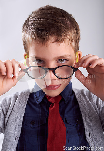 Image of Glasses, serious and portrait of child in studio for eye care, vision and optical health. Looking, optometry and young boy kid with stylish eyewear or spectacles isolated by white background.