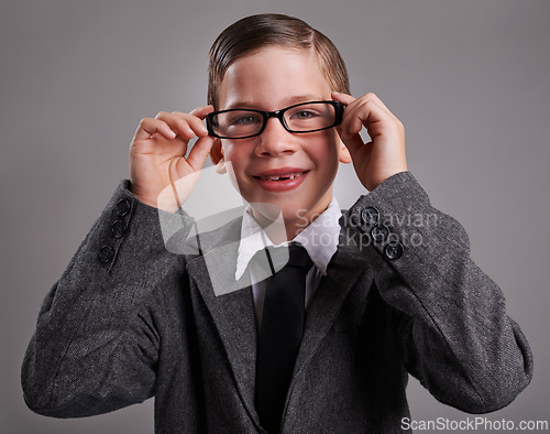 Image of Portrait, costume and boy with glasses, business and Halloween dress up on a grey studio background, Face, person and model with vision and eyewear with child development and smile with retro clothes