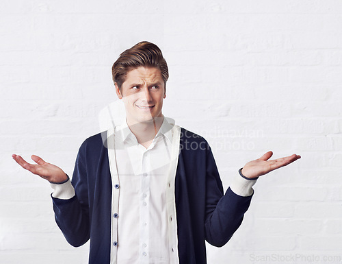 Image of Confused, thinking and man with doubt on a white background for choice, option and decision. Facial expression, reaction and isolated person with unsure, question and wonder shrug gesture in studio