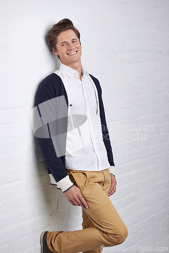 Image of Smile, fashion and portrait of man by wall with casual, cool and trendy outfit for confidence. Happy, handsome and young male person with attractive style standing by white brick background.