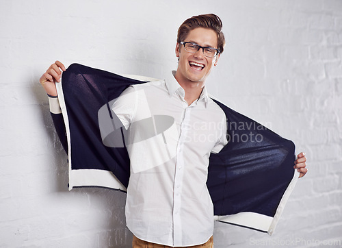 Image of Man, portrait and smile with confidence or fashion on wall background or cool, happiness or style. University student, face and glasses or jacket as relaxing or pride in Canada, excited or expression