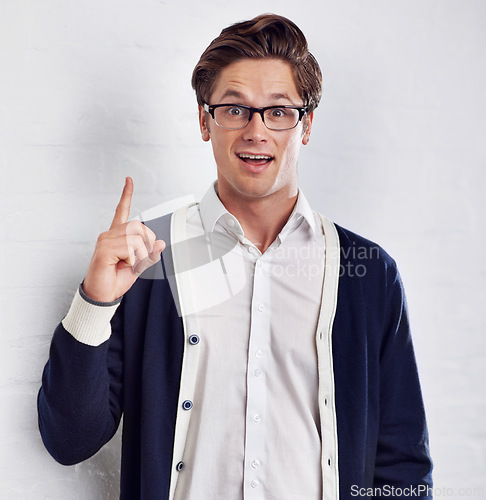 Image of Happy man, portrait and idea for solution, decision or choice with glasses on a white studio background. Face of young male person pointing up in surprise for problem solving or plan on mockup space