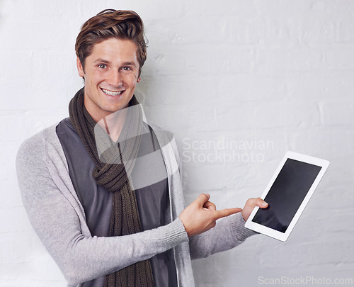 Image of Happy man, portrait and pointing to tablet screen for advertising or marketing on a white studio background. Young and handsome male person with smile, showing technology display or mockup space