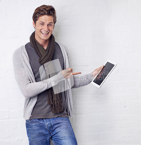 Image of Excited man, portrait and pointing to tablet screen for advertising or marketing on a white studio background. Happy and handsome male person with smile, showing technology display or mockup space