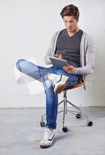 Image of Man, chair and tablet with surprise for online technology on wall background for communication, streaming or internet. Male person, wow and digital search for connectivity, gaming or social media